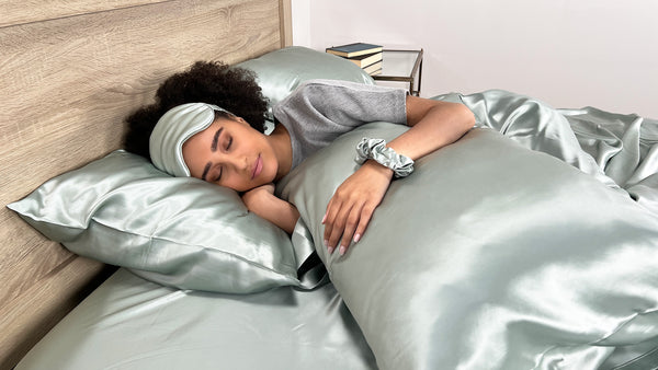 Young woman wearings age sleep mask in silk bedding