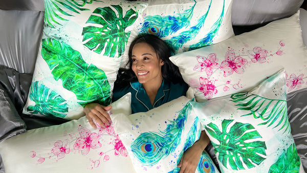 Woman lies in bed surrounded by the Gallery Collection Pillowcases