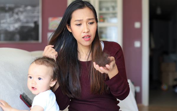 Mother experiencing postpartum hair loss