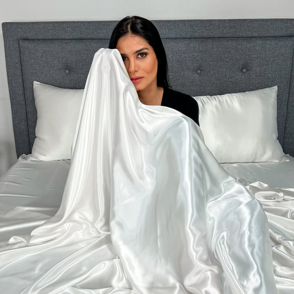 Model in White Silk Sheets Holding them close to her face.