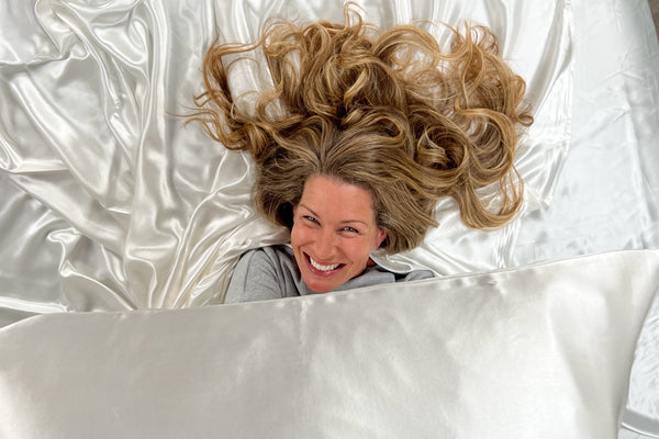 Model with Blonde Hair Smiling on Silk Bedding