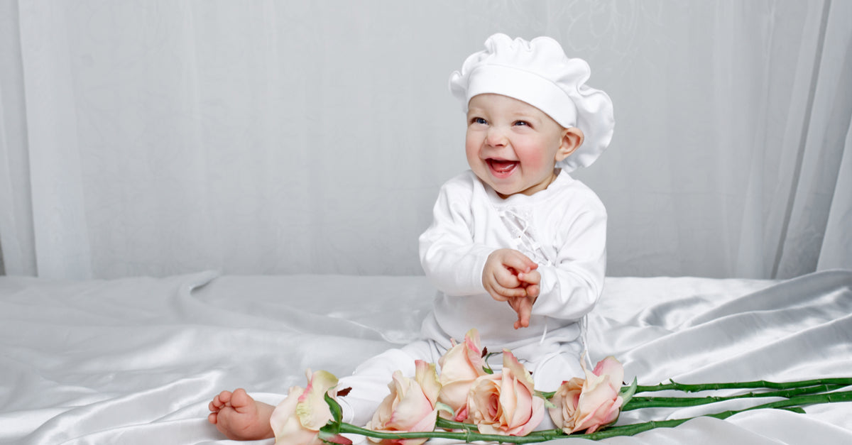 baby  girl sitting on ivory silk crib sheet by Mulberry Park silks