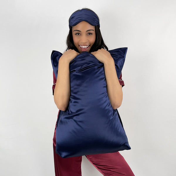 Model Holds 30 mm silk pillowcase in Navy wearing matching sleep mask