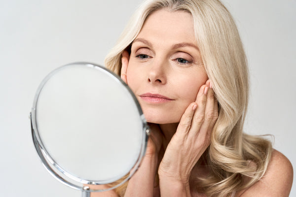 Woman Looking at Skin in the Mirror