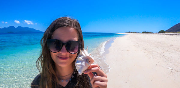 A women with a shell on the beach 