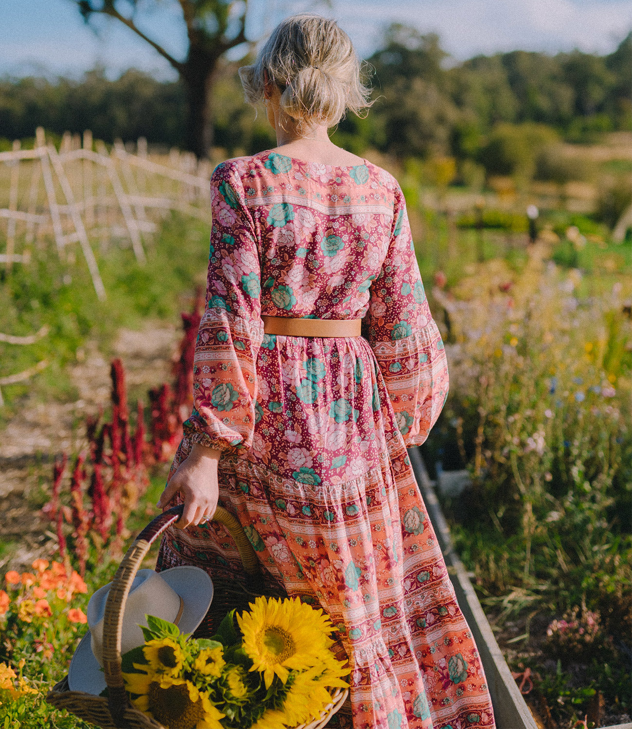 Jodi Flockhart wears the Arnhem Sundress in Ruby in the flower fields at Sault on Dalesford