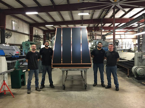 custom black range hood with polished copper straps