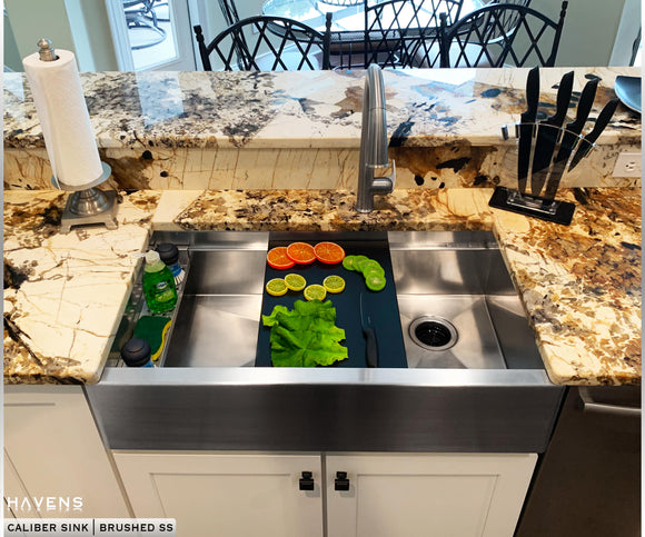 Custom farmhouse stainless steel sinks with a built-in ledge for advanced sink accessories.