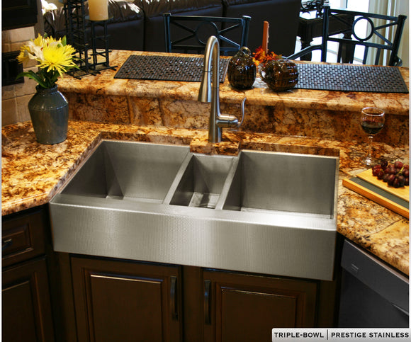 Triple bowl stainless steel farmhouse sink with 3 bowls and a large wash basin on either side. Custom stainless steel farm sink.