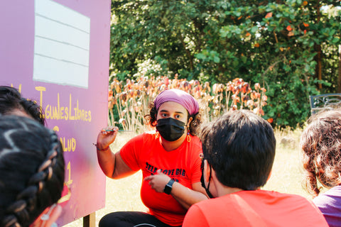 Taller Salud member painting house while wearing a Valija Intention Tee