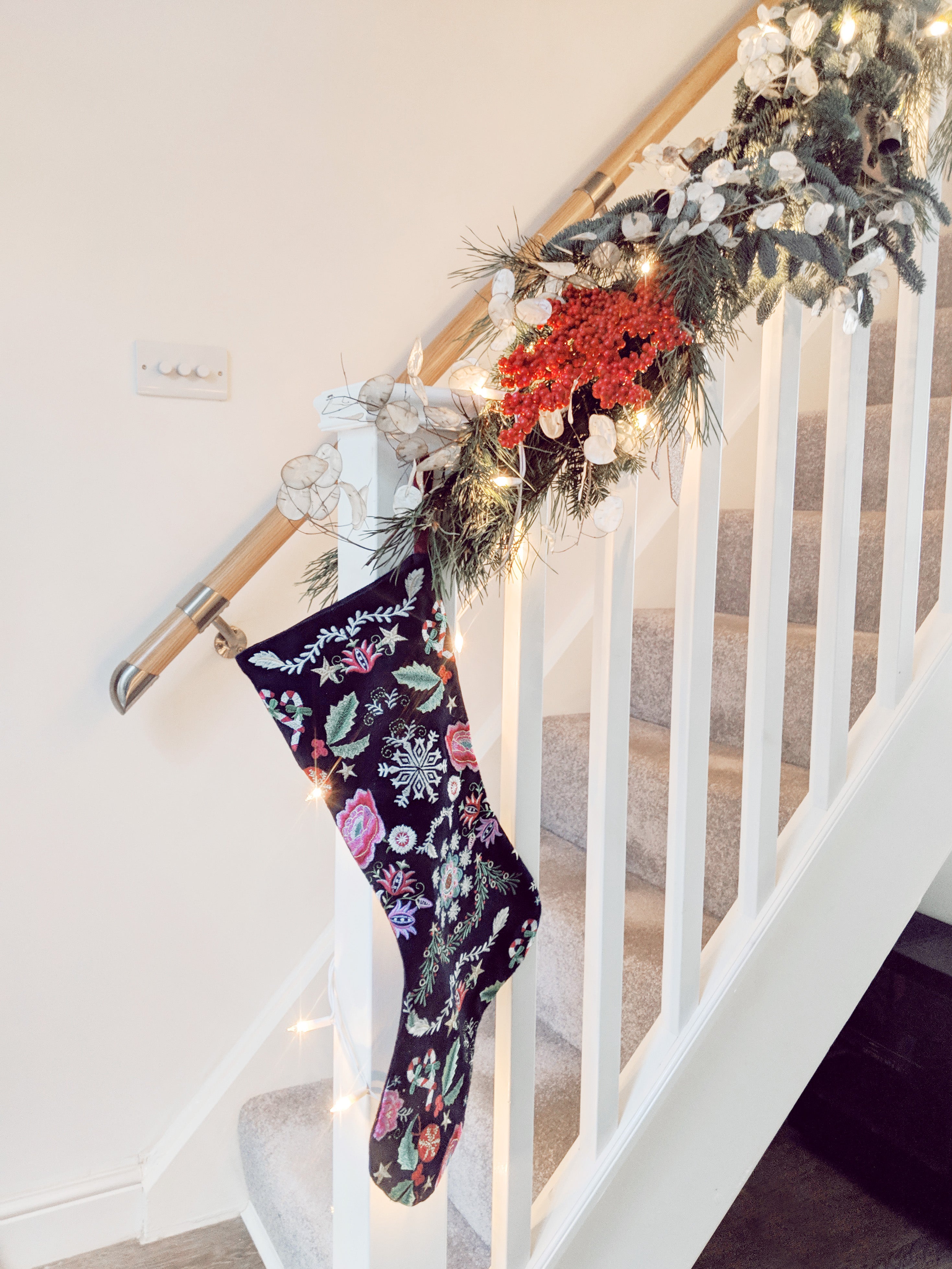 natural christmas decorations hung along stai bannister