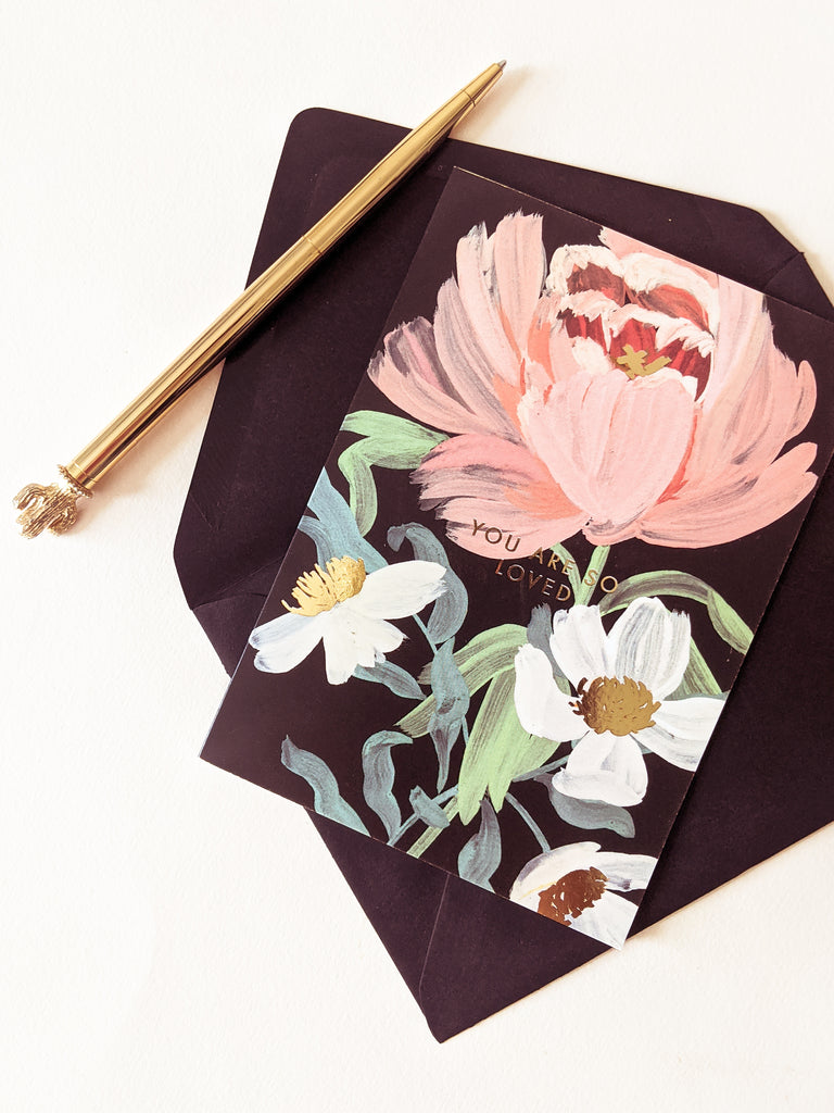 a black card with painted pink peonies reads "you are so loved"