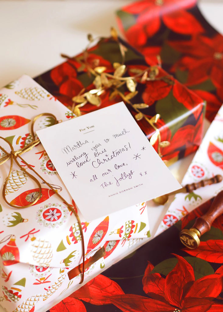 gift wrapped orders with illustrated christmas paper, with gold satin cord and a handwritten note