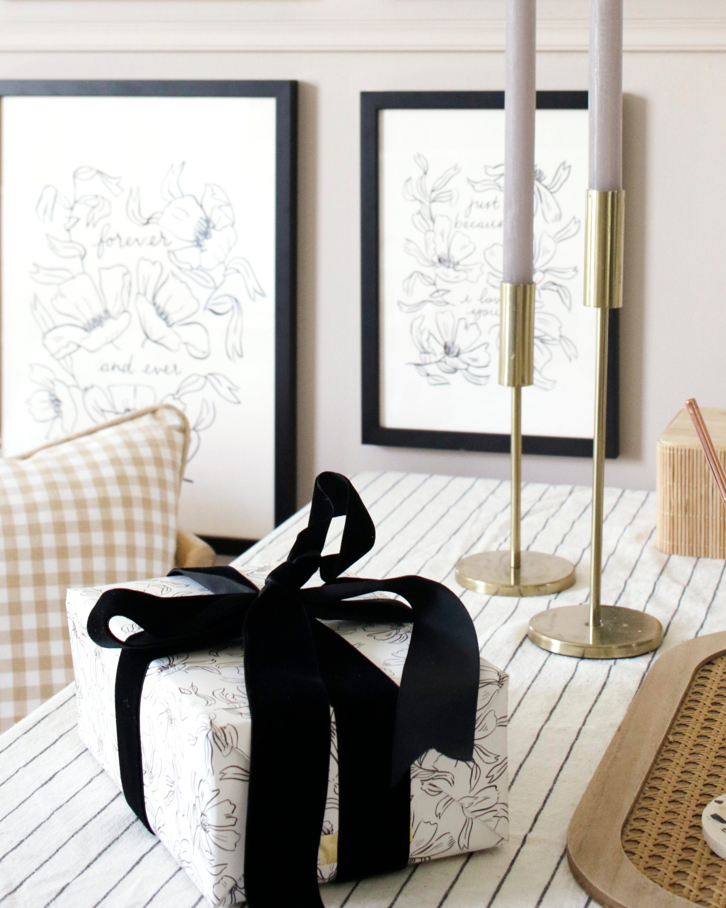 a gift wrapped in lovely, linework floral style wrapping paper, finished with a luxurious black velvet ribbon