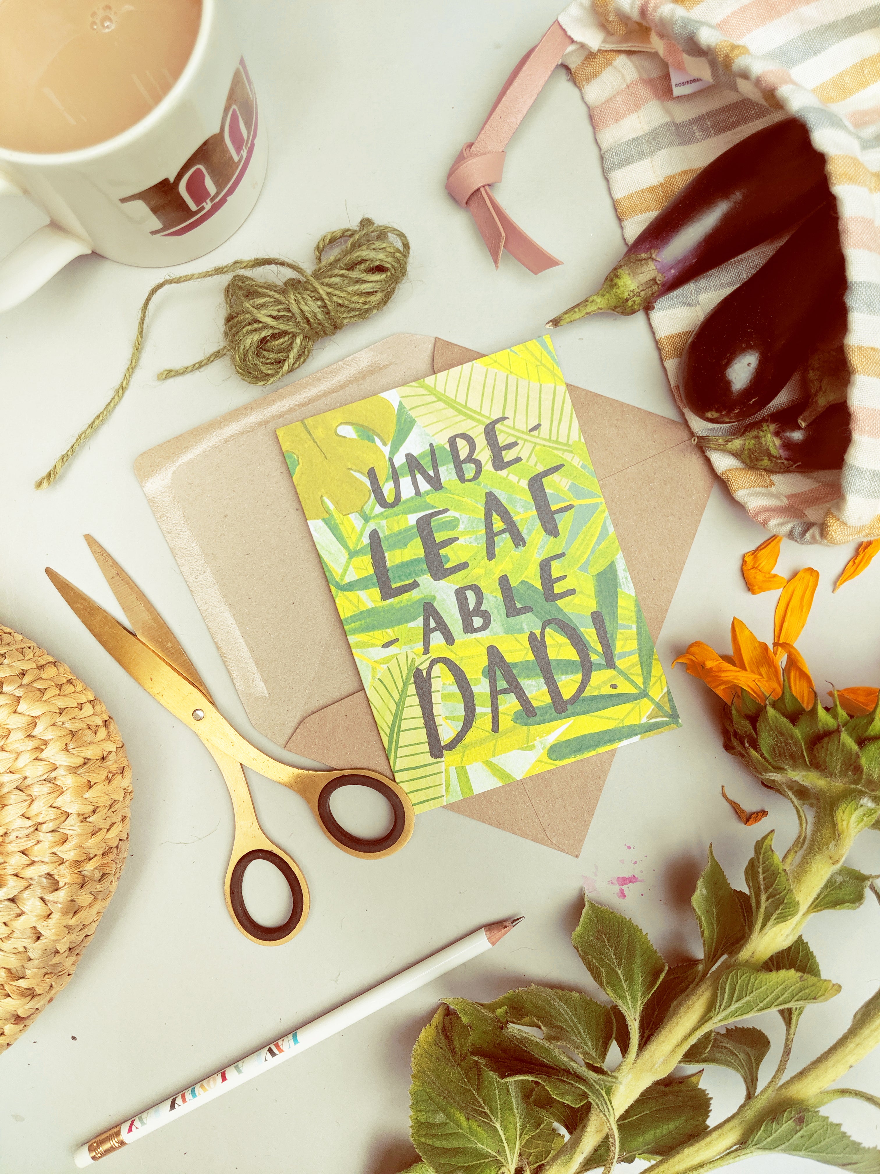 father's day card surrounded by freshly grown produce, a cuppa and some sunflowers