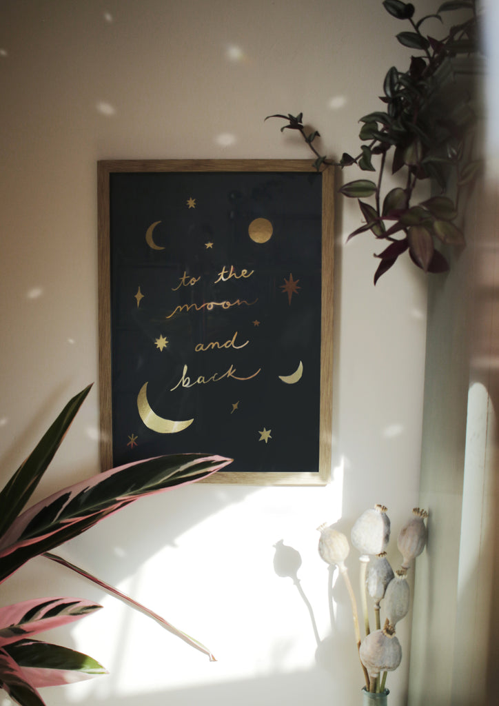 gold foiled to the moon and back celestial print in a wooden frame