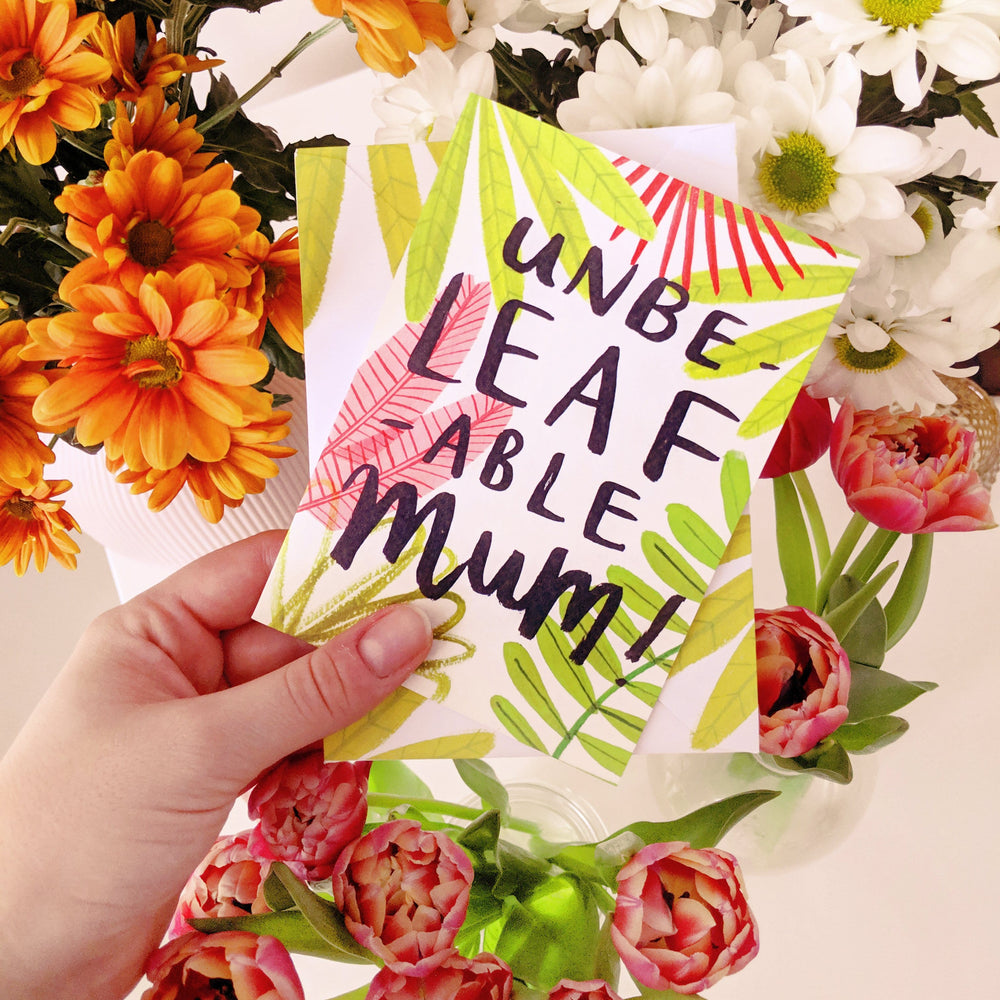 mother's day card help up against bunches of flowers