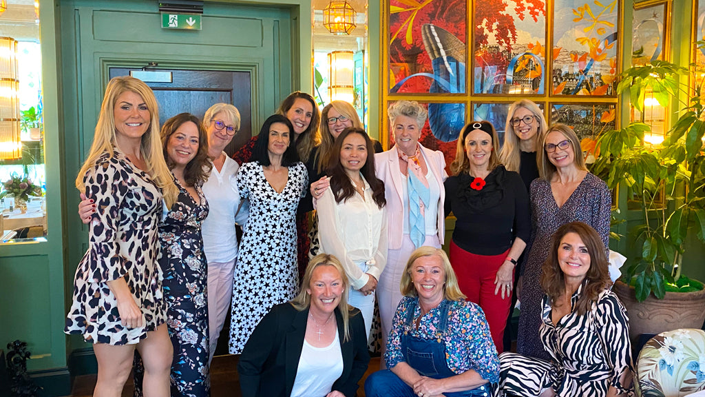 Photo showing a group of smiling women standing together indoors at the Ivy Birmingham