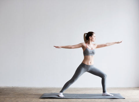 Woman stretching on yoga mat. Focus on fitness to beat Blue Monday & the January Blues - Absolute Collagen