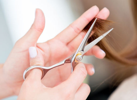 Person cutting hair. How to get your hair longer and stronger