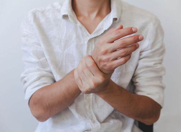 Person holding wrists in pain, indicating collagen for joint pain