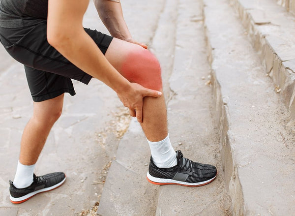 Man in workout gear holding knee in pain, showing collagen for injuries