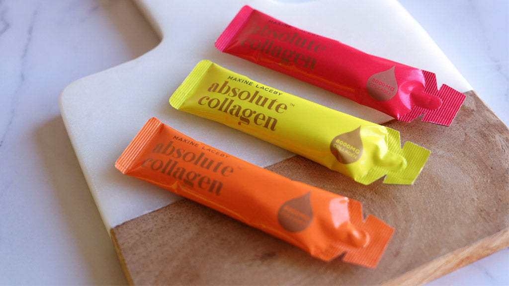 Photo showing three different flavoured sachets of Absolute Collagen laying on a chopping board