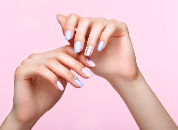 Pink and purple manicured nails on pink background, showing collagen for nail growth