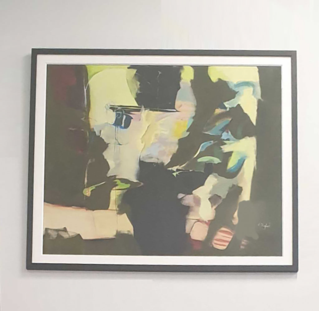 Photo of an abstract art piece in black and yellow, hanging on a white wall