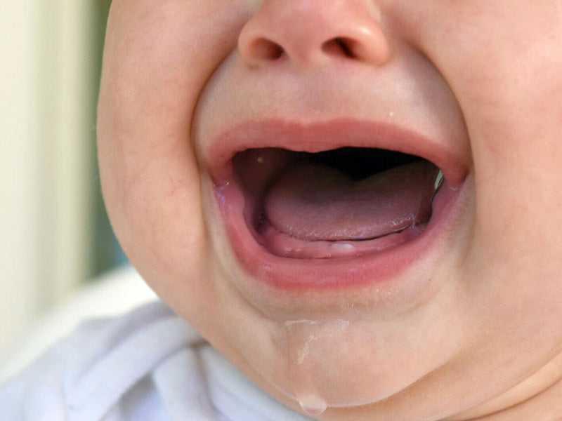 baby cutting first tooth