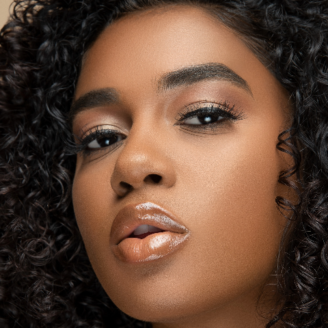 Deeper skin tone model wearing bronze and gold shade of makeup