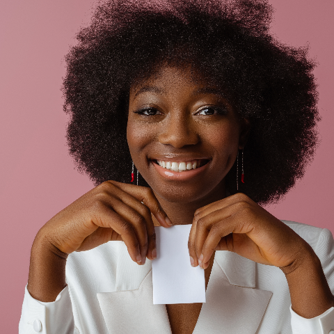 African American model demonstrating how to find skin undertone with white piece of paper