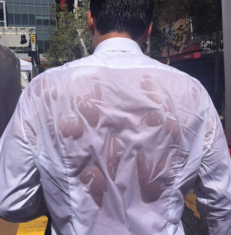 man walking outside and sweating a lot through his shirt