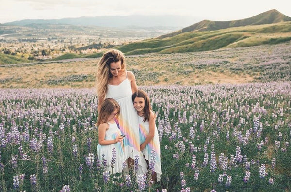 Mom with daughters in mommy and me pastel rainbow dresses