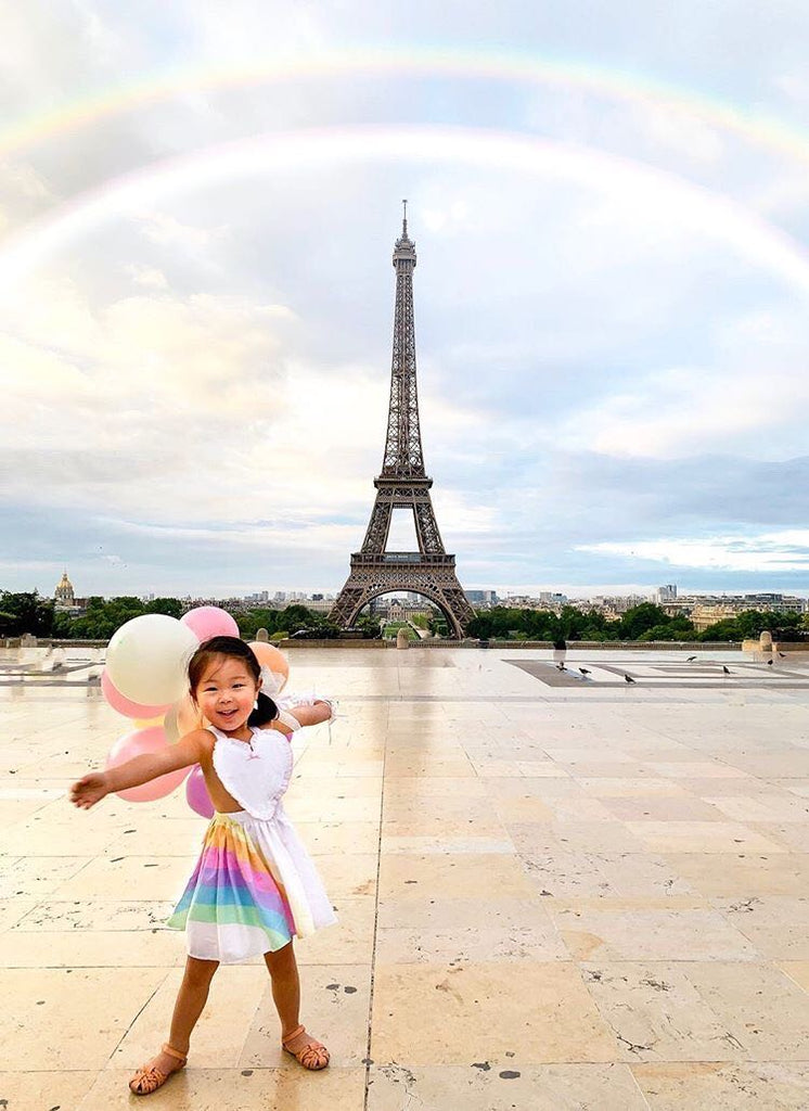 A child wearing the pastel penny in front of the Eiffel Tower 