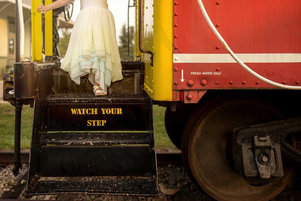 child walking off a train wearing the sea glass Stella. pleiades designs and the traveling dress collective