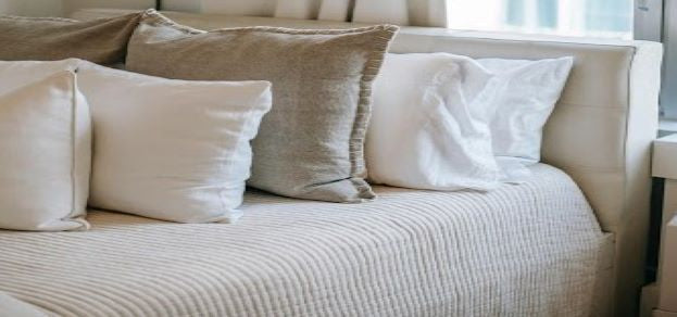 Neutral cushions on a bed