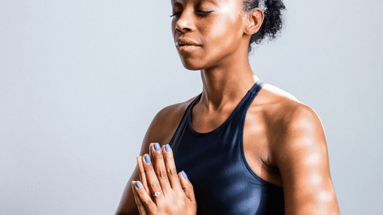 woman holding hands in front of chest in a yoga pose