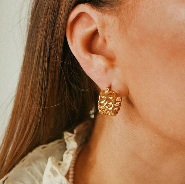 A model wearing the Woven Gold Hoops.