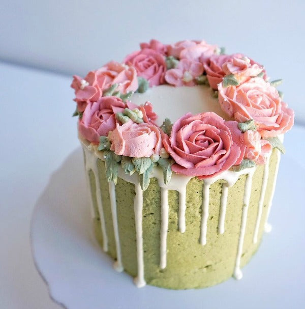 Delicous matcha cake topped with smooth matcha buttercream and roses