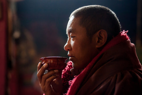 monk drinking a cup of tea