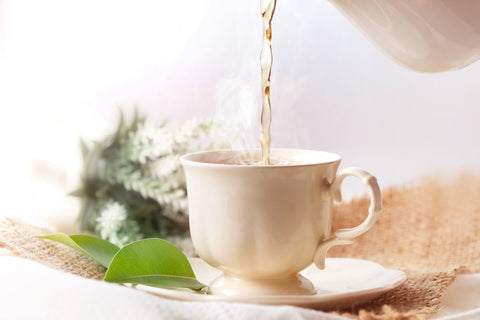 white tea being poured from a teacup