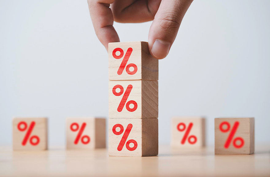 A stack of wooden blocks printed with red percentage symbols