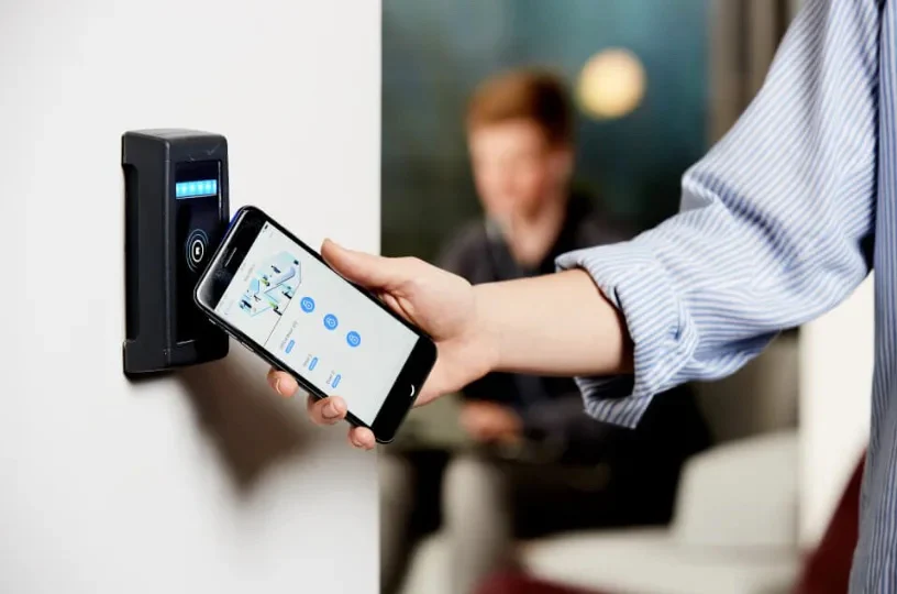 Person hovering mobile device over NFC reader