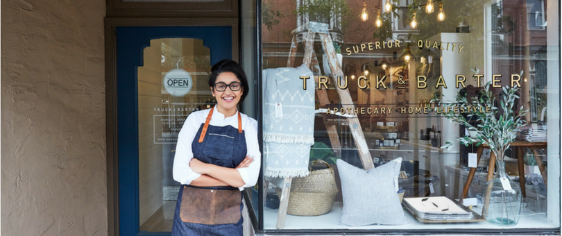 Woman in front of brick-and-mortar store | Shopify Retail blog