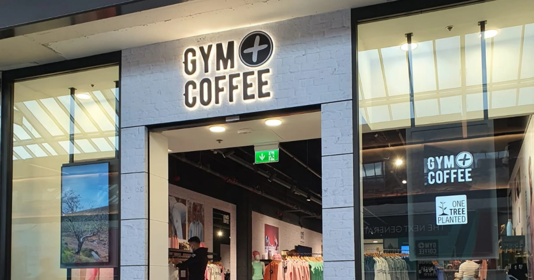 Storefront for a gym wear retailer with digital screens either side of the entrance.