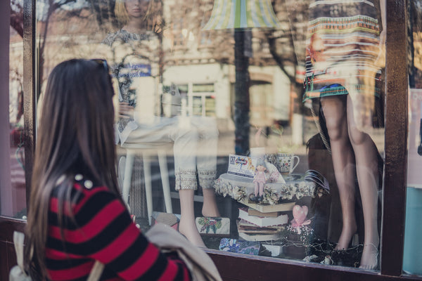 Eine Frau schaut in ein Schaufenster. Ein beliebter Job im Einzelhandel ist der Visual Merchandiser bzw. Visual Merchandiserin.