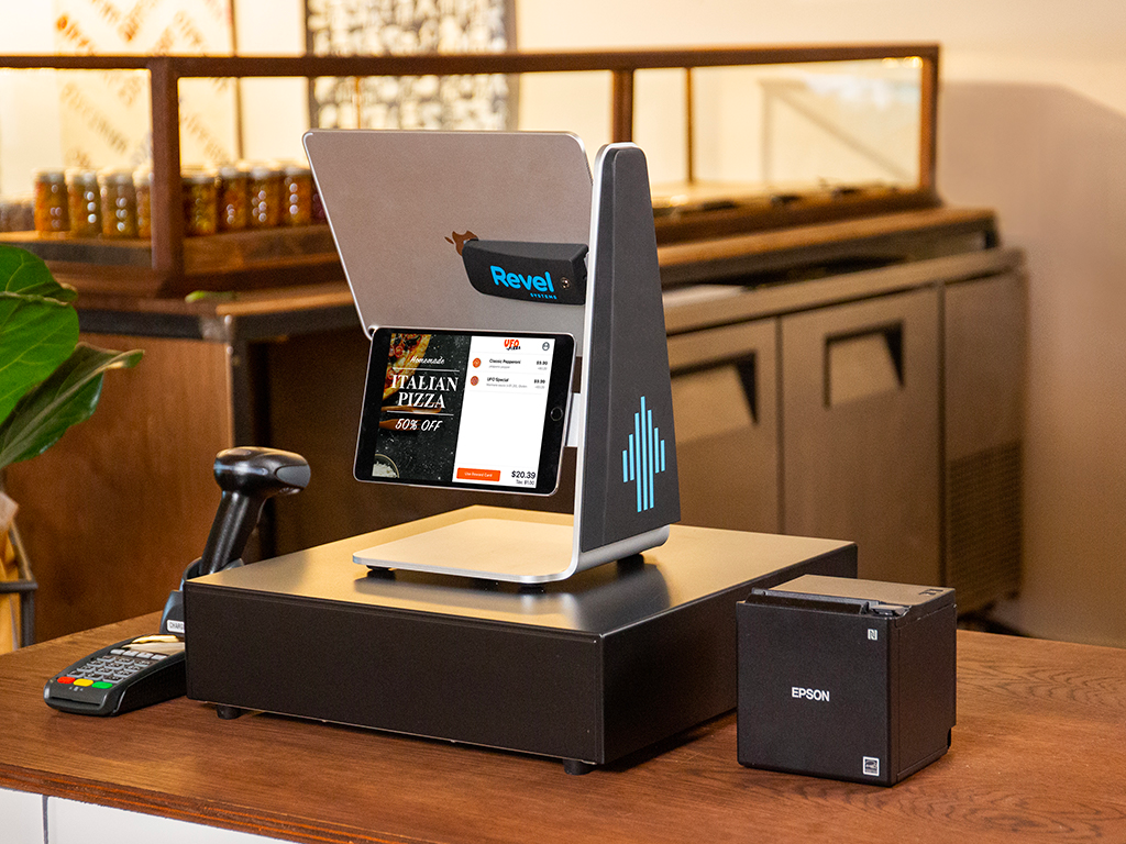 A selection of Revel POS hardware, including a payment terminal, card reader, and receipt printer.