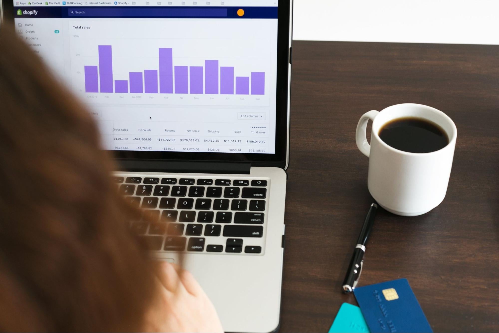 A business owner running a store online checks out their sales in a report on their laptop.