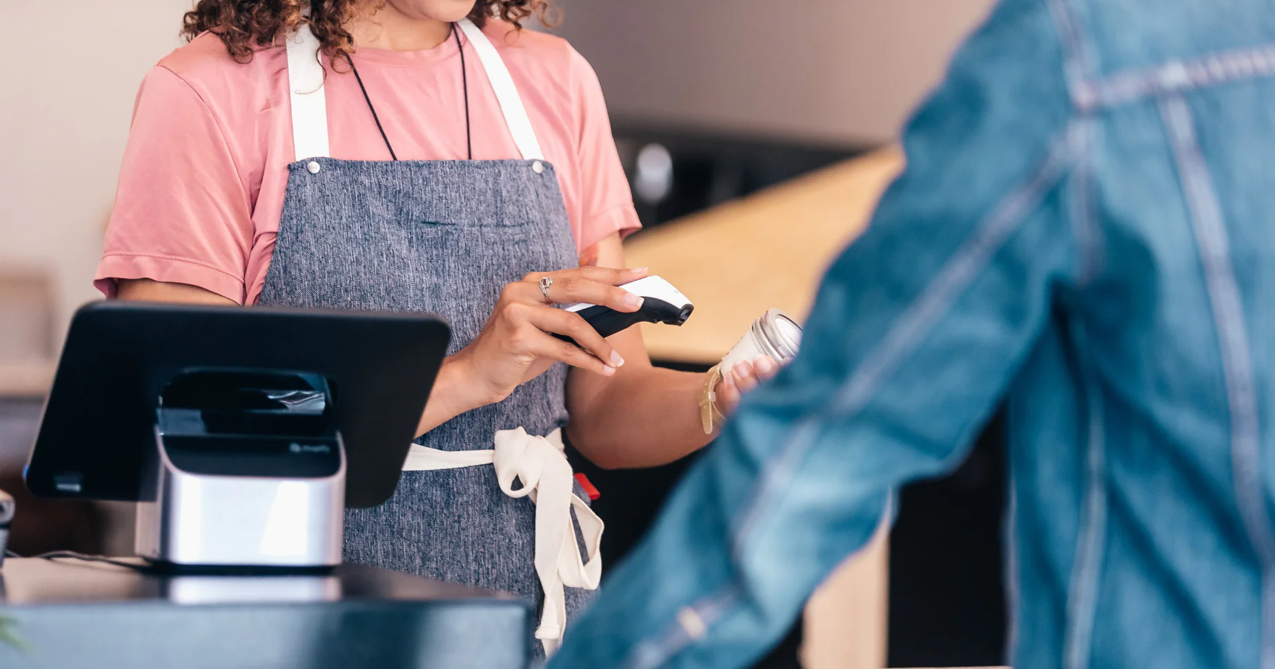 retail employee scanning product at checkout